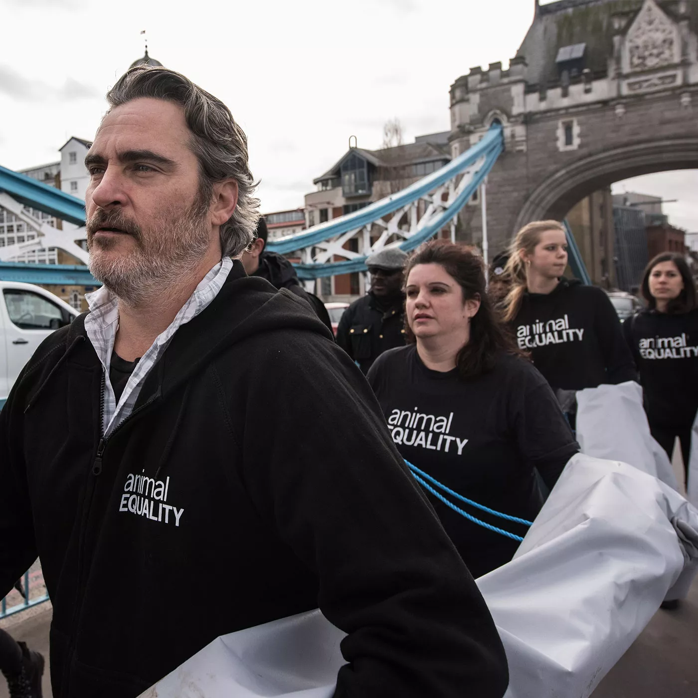 Joaquin Phoenix protesta junto con activistas de Igualdad Animal en el Puente de Londres y camina cargando la pancarta