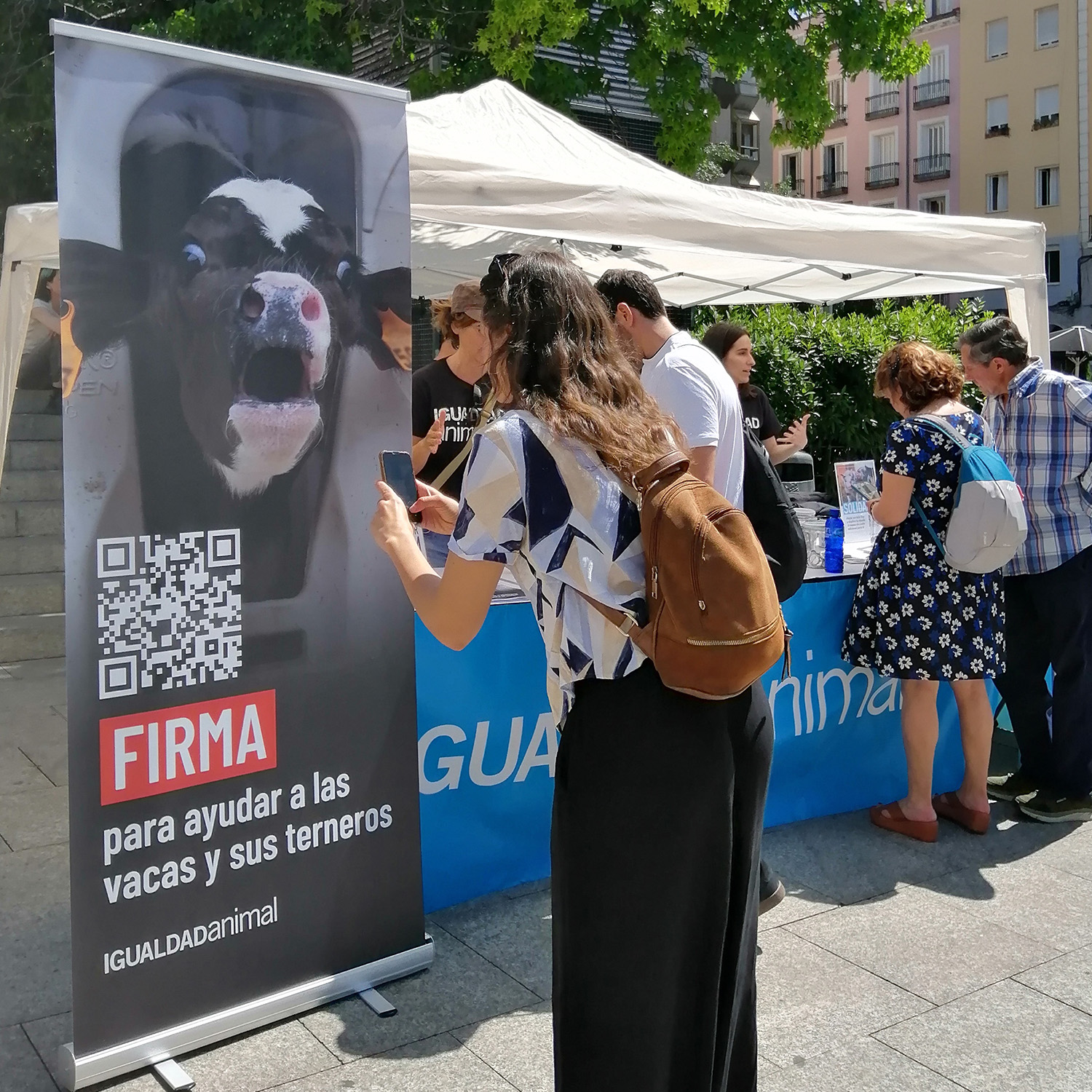 Varias personas miran la mesa informativa de Igualdad Animal