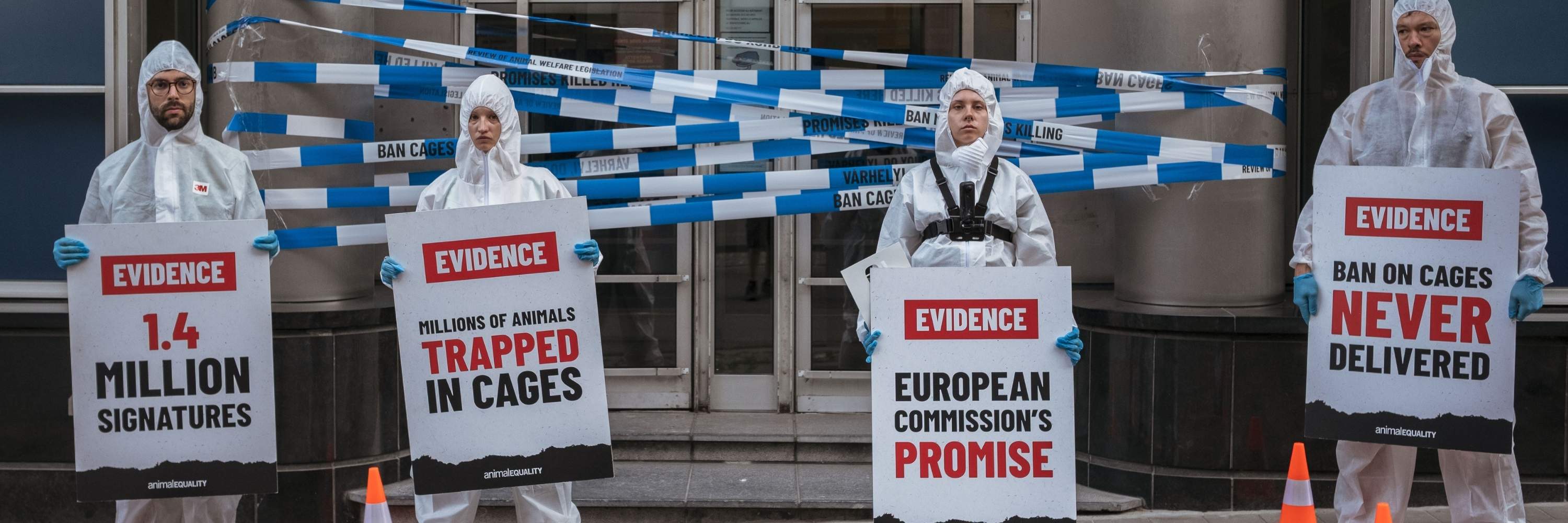 Activistas de Igualdad Animal vestidos con trajes de protección blancos recrean una escena del crimen ante la sede de la DG SANTE.